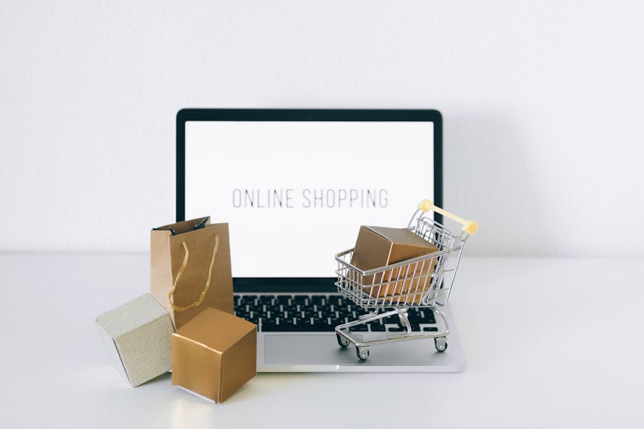 pexels-photo-6214474-6214474 Laptop displaying online shopping with boxes and cart, representing ecommerce.